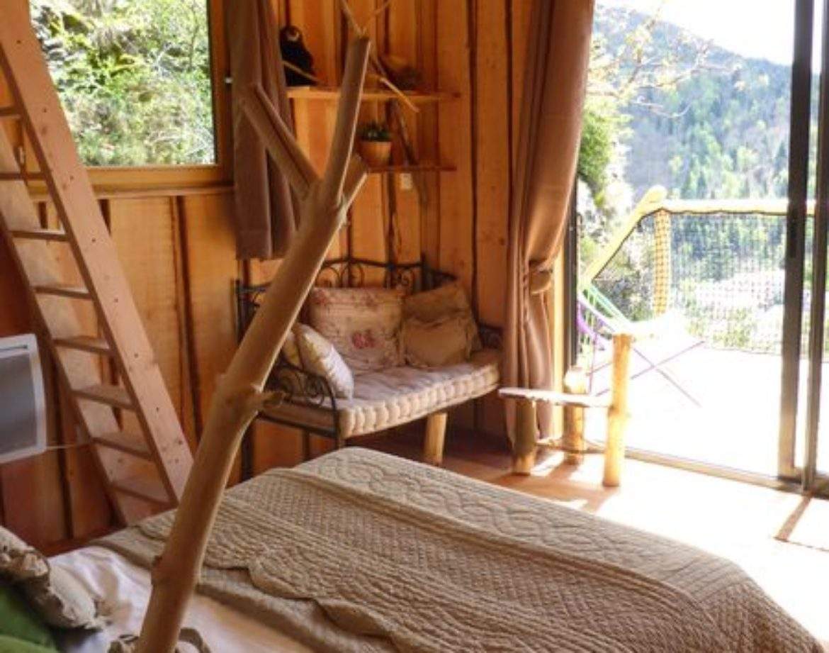 Cabane en bois dans le Languedoc-Roussillon, avec vue sur la nature et un intérieur chaleureux.