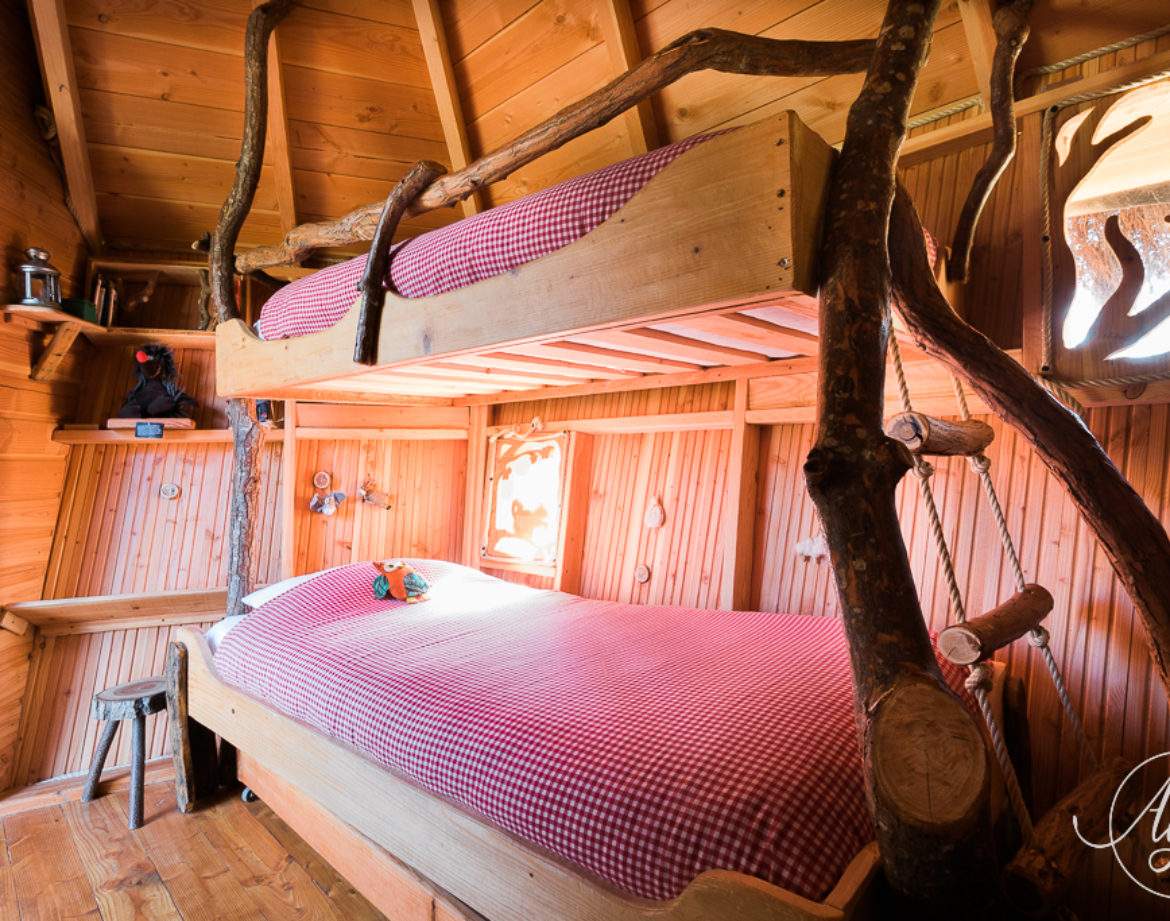 Chalet en bois avec lits superposés, ambiance chaleureuse et décor naturel.