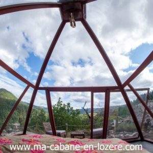 Cabane en verre avec vue panoramique sur la nature verdoyante du Languedoc-Roussillon.