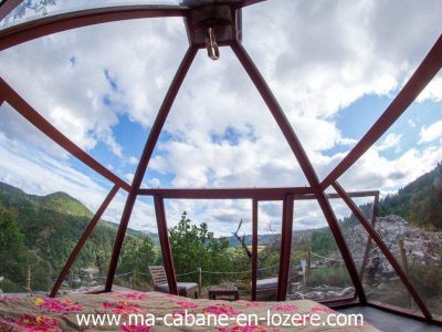 Cabane en verre avec vue panoramique sur la nature verdoyante du Languedoc-Roussillon.