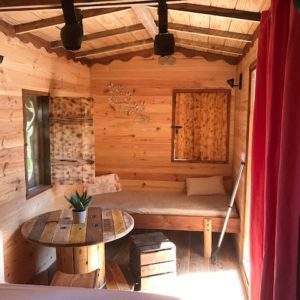 Cabane en bois chaleureuse avec un coin salon et des murs en bois naturel.