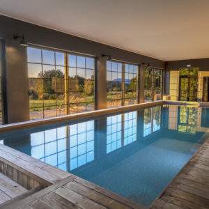 Hébergement insolite en Corse avec piscine intérieure et grandes baies vitrées.