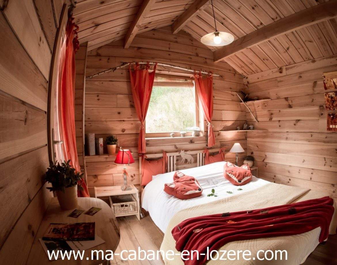 Cabane en bois cosy à Languedoc-Roussillon, avec lit douillet et décor chaleureux.