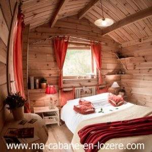 Cabane en bois cosy à Languedoc-Roussillon, avec lit douillet et décor chaleureux.