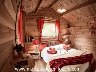 Cabane en bois cosy à Languedoc-Roussillon, avec lit douillet et décor chaleureux.