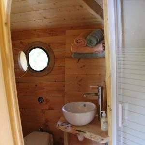 Hébergement insolite en Pays de la Loire : salle de bain en bois avec lavabo rond.