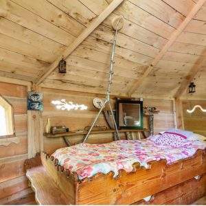 Cabane en bois à Champagne-Ardenne, avec un lit douillet et des lanternes décoratives.