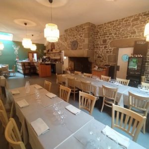 Hébergement insolite en Basse-Normandie : salle à manger chaleureuse avec pierres apparentes.