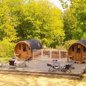 Hébergement insolite en Basse-Normandie : cabanes en bois sur une terrasse ensoleillée.