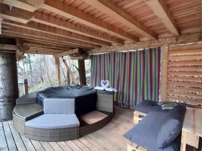 Cabane perchée en Auvergne-Rhône-Alpes avec jacuzzi et décoration colorée.