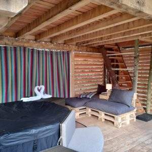 Hébergement insolite en Auvergne-Rhône-Alpes, avec un jacuzzi et des coussins confortables.