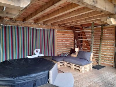 Hébergement insolite en Auvergne-Rhône-Alpes, avec un jacuzzi et des coussins confortables.