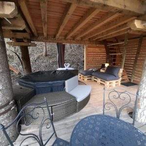 Cabane perchée en Auvergne-Rhône-Alpes avec jacuzzi et mobilier en palettes.