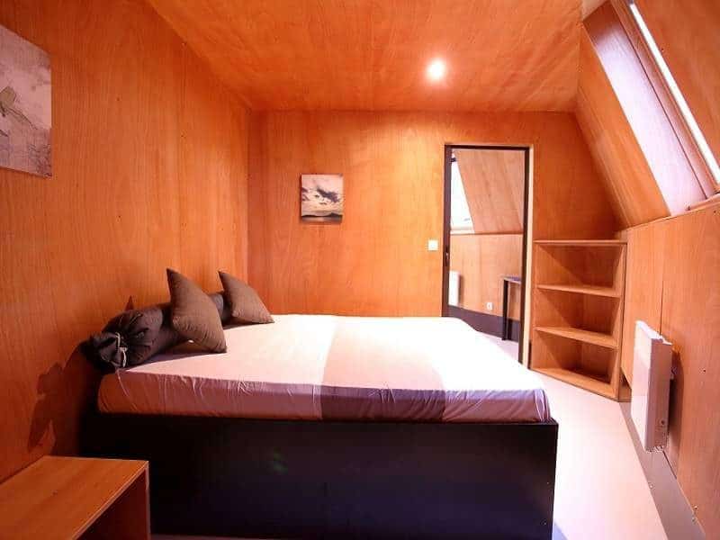 Chalet moderne avec un lit confortable et des murs en bois chaleureux.