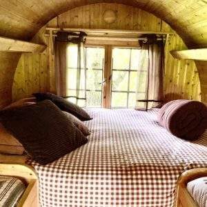 Cabane en bois cosy avec lit douillet et vue sur la nature en Basse-Normandie.
