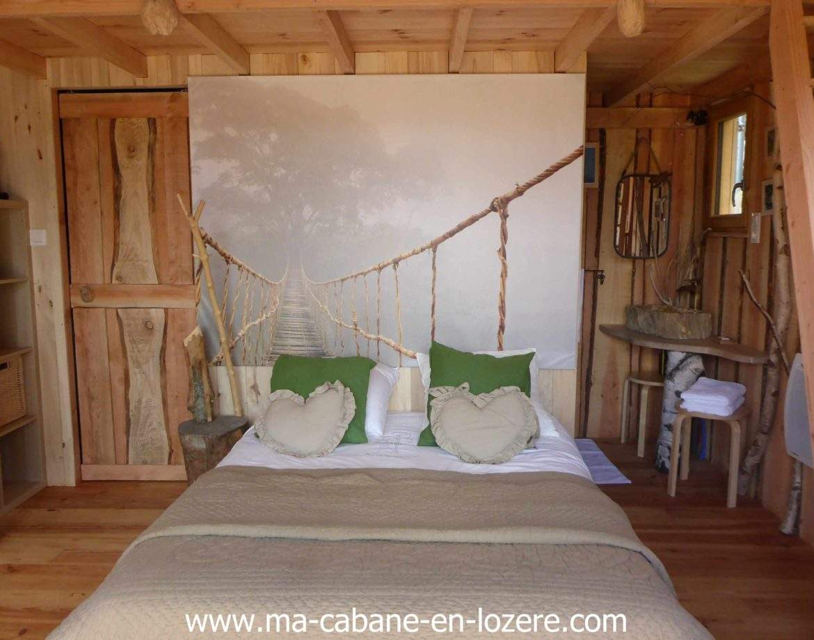 Cabane en bois dans le Languedoc-Roussillon, avec un mur décoré dun pont suspendu.