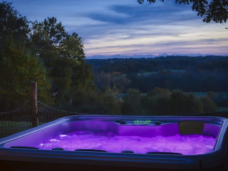 Hébergement en chalet avec jacuzzi lumineux, vue panoramique sur la nature.