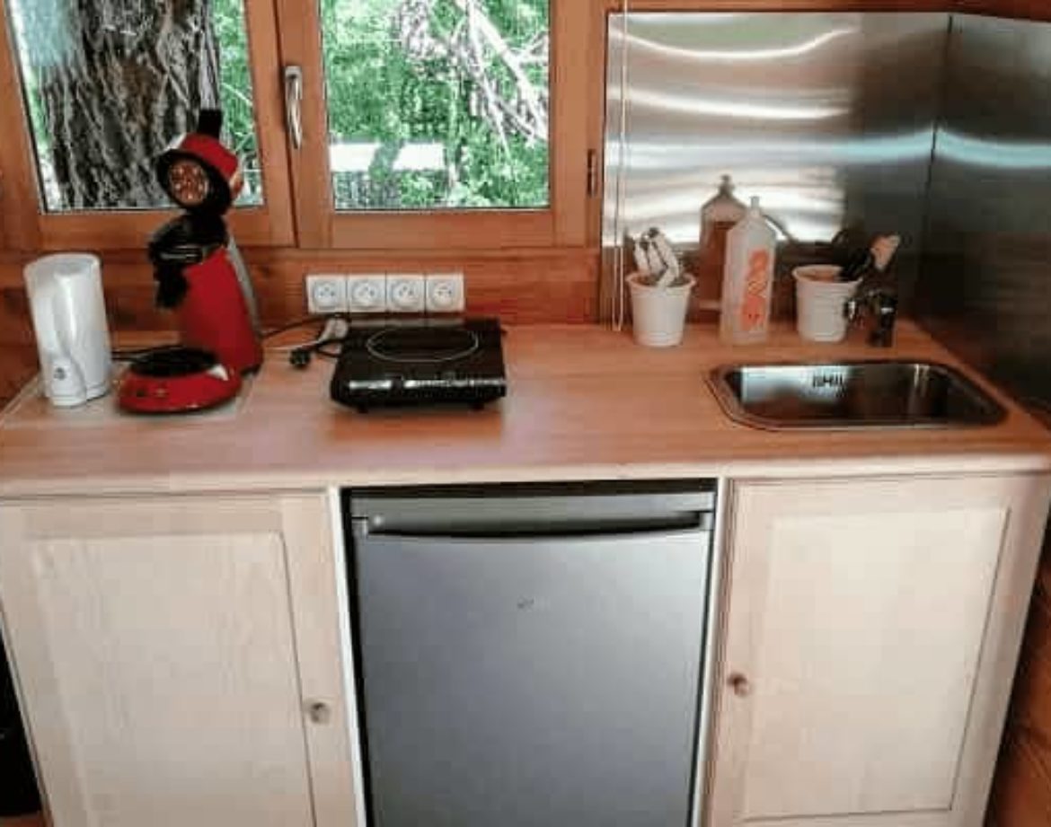 Cuisine équipée dans un hébergement insolite en bois, au cœur de la nature.