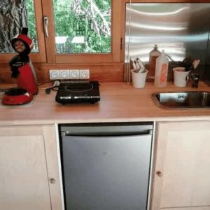 Cuisine équipée dans un hébergement insolite en bois, au cœur de la nature.