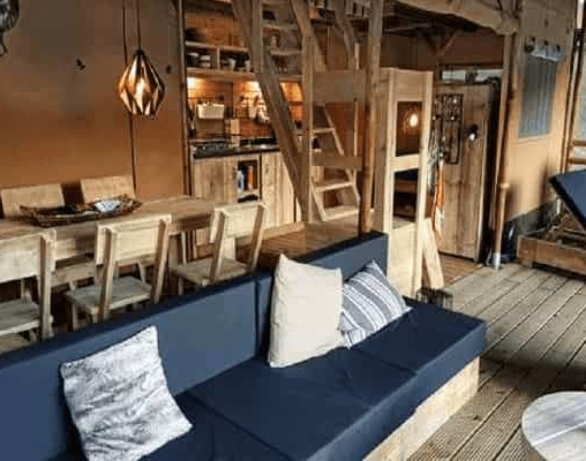 Hébergement insolite en Centre : cabane en bois avec salon cosy et cuisine équipée.