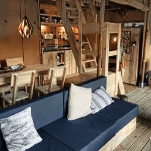 Hébergement insolite en Centre : cabane en bois avec salon cosy et cuisine équipée.