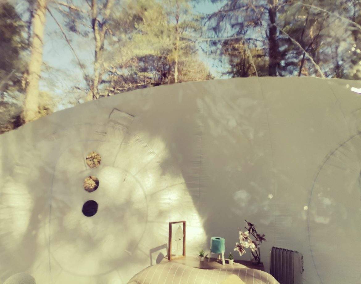 Hébergement insolite en bulle, avec vue sur la nature et décoration intérieure chaleureuse.