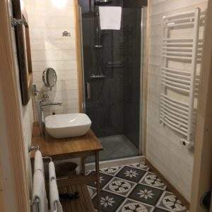 Salle de bain moderne dun hébergement insolite en Aquitaine, avec carrelage décoratif.