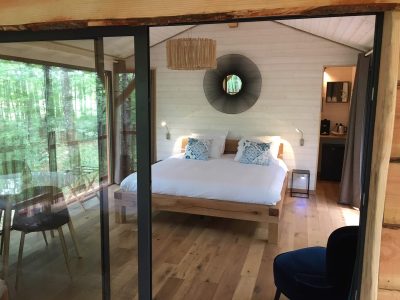 Chalet en bois avec lit douillet et vue sur la forêt en Aquitaine.