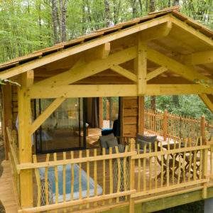Cabane en bois perchée, entourée darbres verdoyants en Aquitaine.