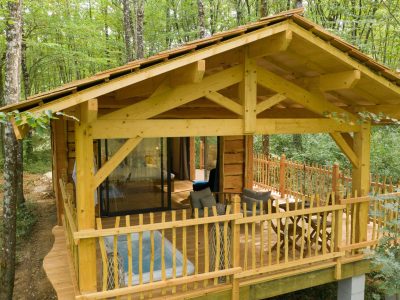 Cabane en bois perchée, entourée darbres verdoyants en Aquitaine.