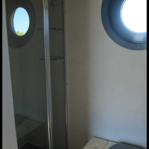 Salle de bain dun hébergement insolite en Midi-Pyrénées avec fenêtre ronde.