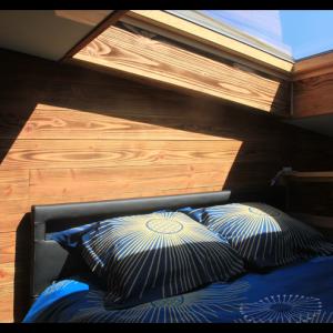 Chalet en bois avec lit confortable et lumière naturelle à Midi-Pyrénées.