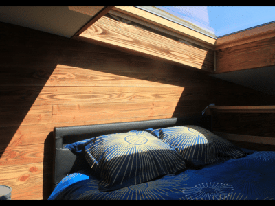 Chalet en bois avec lit confortable et lumière naturelle à Midi-Pyrénées.