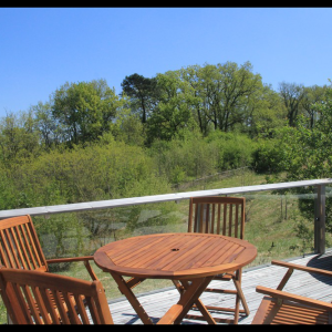 Hébergement insolite en Midi-Pyrénées avec terrasse en bois et vue sur la nature verdoyante.