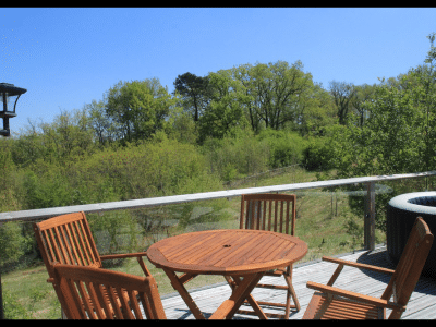 Hébergement insolite en Midi-Pyrénées avec terrasse en bois et vue sur la nature verdoyante.