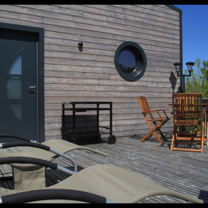 Hébergement insolite en Midi-Pyrénées, avec terrasse en bois et chaises longues confortables.