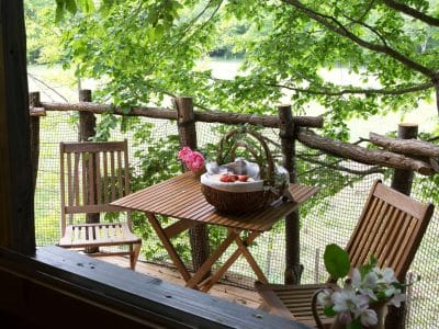 Cabane perchée en Nouvelle-Aquitaine avec terrasse en bois et vue sur la nature.
