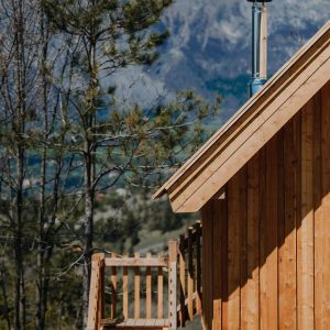 Cabane en bois avec cheminée, entourée de montagnes en Provence-Alpes-Côte dAzur.