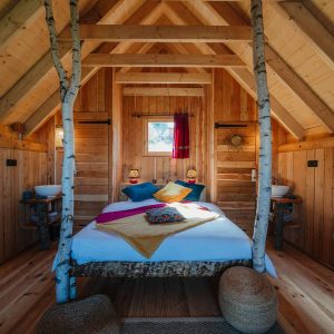 Chalet en bois chaleureux avec lit douillet et décoration colorée en Provence-Alpes-Côte dAzur.