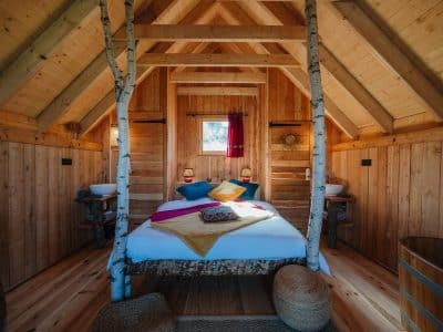 Chalet en bois chaleureux avec lit douillet et décoration colorée en Provence-Alpes-Côte dAzur.