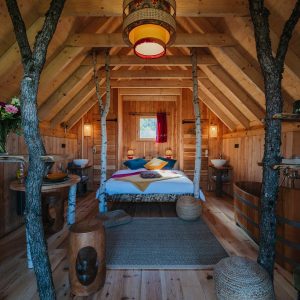 Cabane en bois chaleureuse avec lit douillet et décoration naturelle.