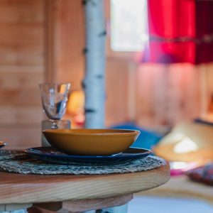 Cabane en bois cosy avec vaisselle colorée et ambiance chaleureuse.