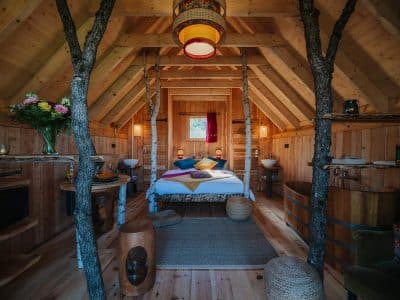 Cabane en bois chaleureuse avec lit douillet et décoration naturelle.