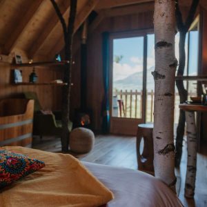 Cabane en bois avec des troncs darbres, vue panoramique sur la nature.