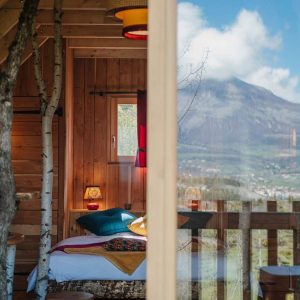 Cabane en bois avec vue sur les montagnes, décorée avec des touches colorées.