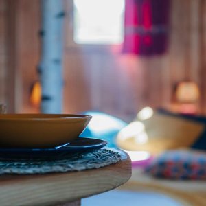 Hébergement insolite en bois en Provence, avec une table décorée et une ambiance chaleureuse.