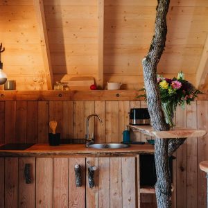 Cabane en bois avec cuisine rustique et décoration florale colorée.