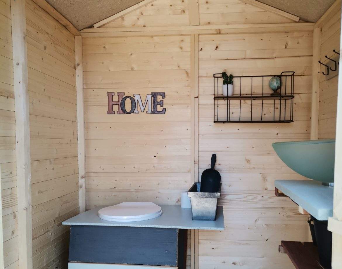 Cabane en bois cosy avec lavabo et décoration minimaliste, idéale pour un séjour unique.
