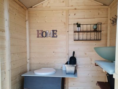 Cabane en bois cosy avec lavabo et décoration minimaliste, idéale pour un séjour unique.