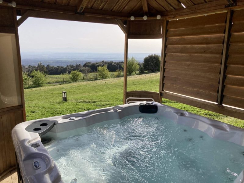 Hébergement en chalet avec jacuzzi, vue panoramique sur la nature environnante.